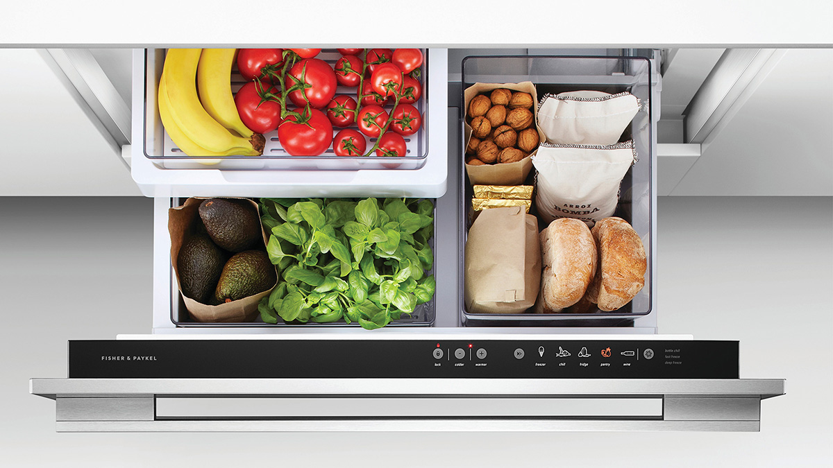 Un tiroir de réfrigérateur ouvert contenant des fruits, des légumes et du pain frais.