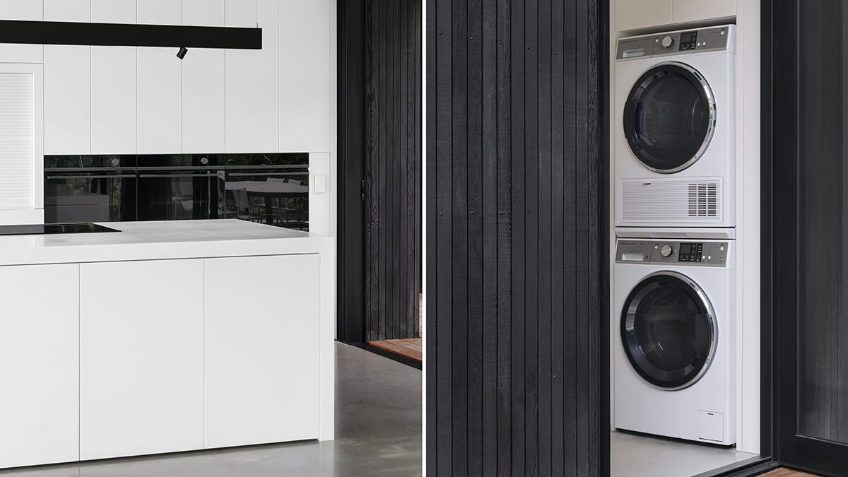 Présentation des fours muraux dans la cuisine et de la salle de lavage qui forme une paire parfaite; la laveuse et la sécheuse sont superposées à la verticale.