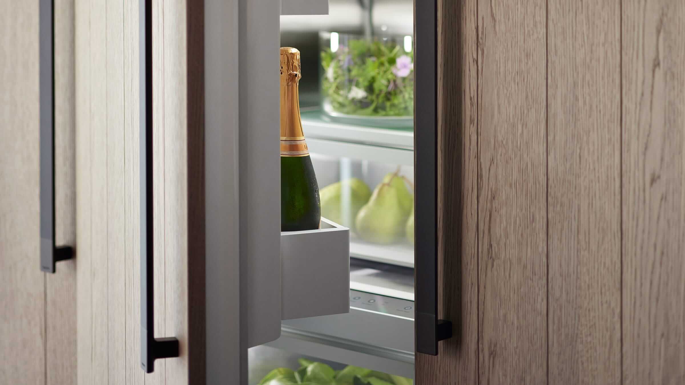 Contemporary kitchen with a person interacting with an integrated column refrigerator