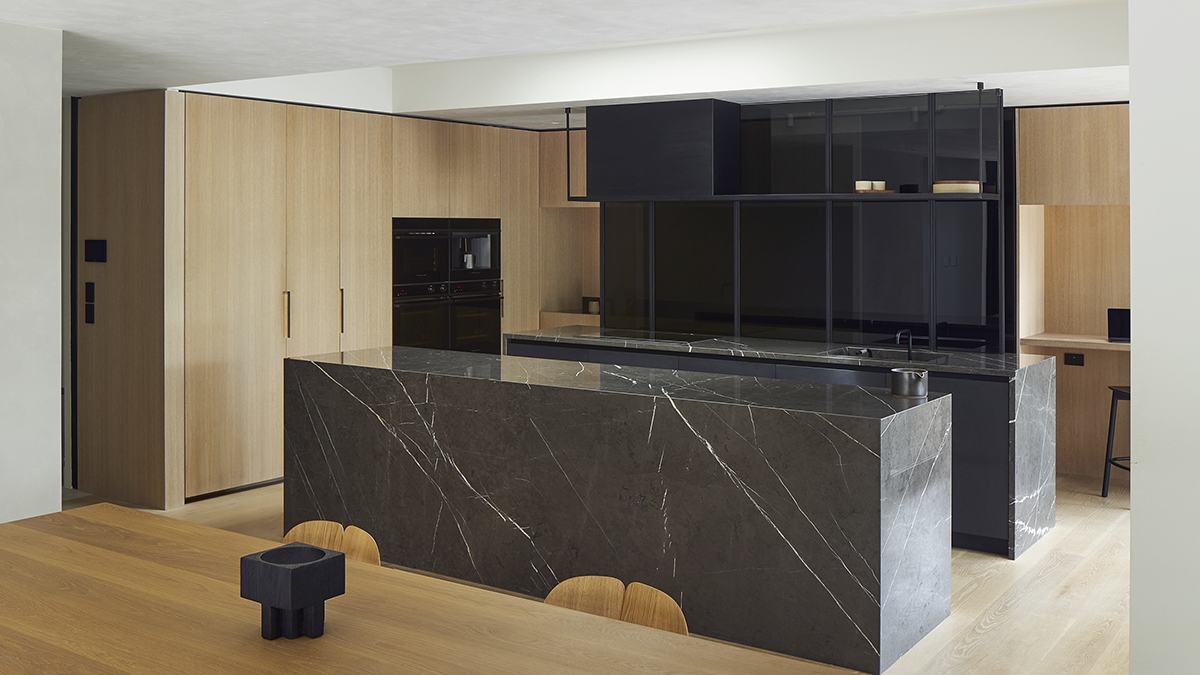 designer kitchen with black marble surfaces overlooking mix of Integrated & Minimal appliances