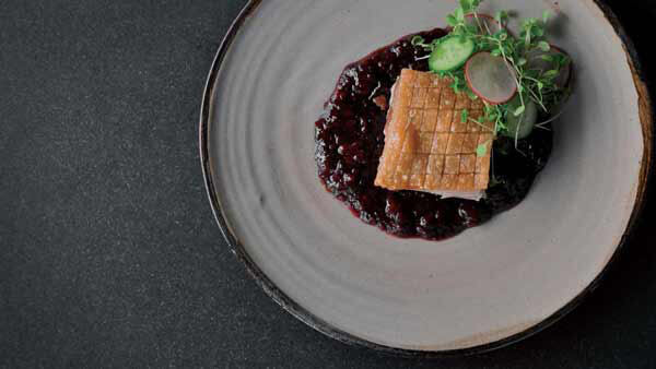 A Gourmet Dish of Garnished Roast Pork with Cranberry Sauce.