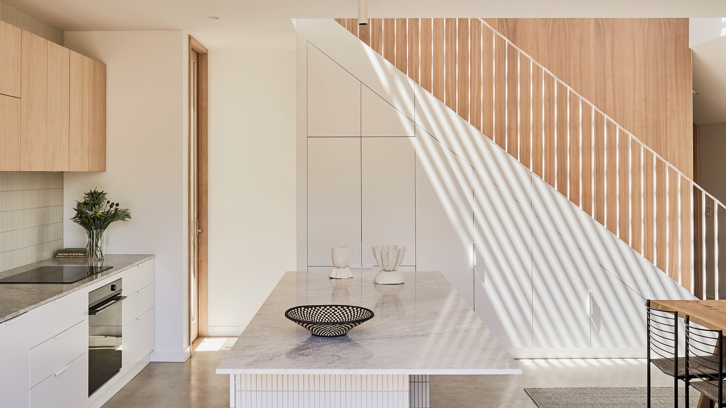 Side shot of the kitchen and ascending staircase, showcasing the minimal style