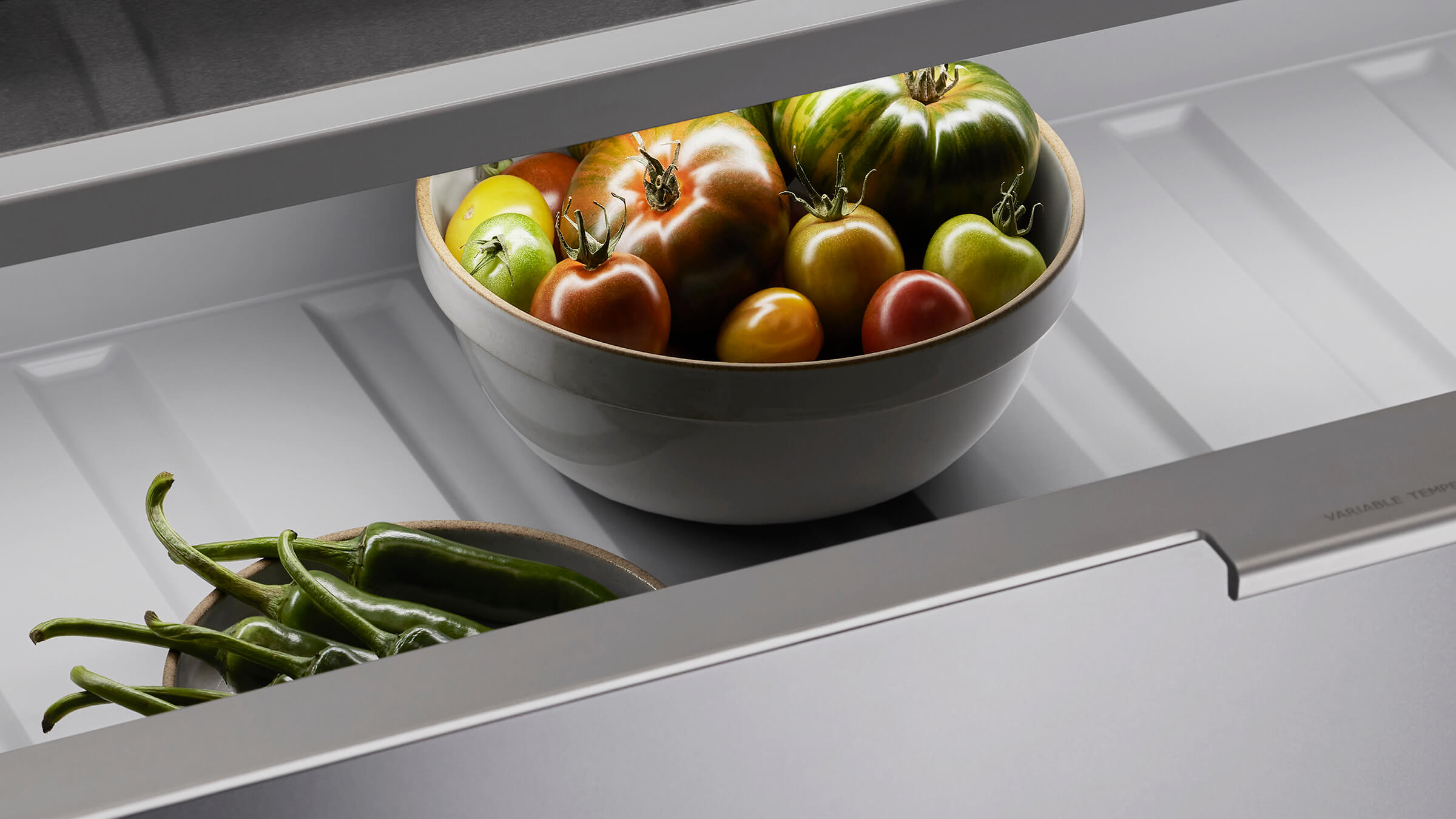Internal view of a vertical refrigerator showing organized food storage across glass shelves