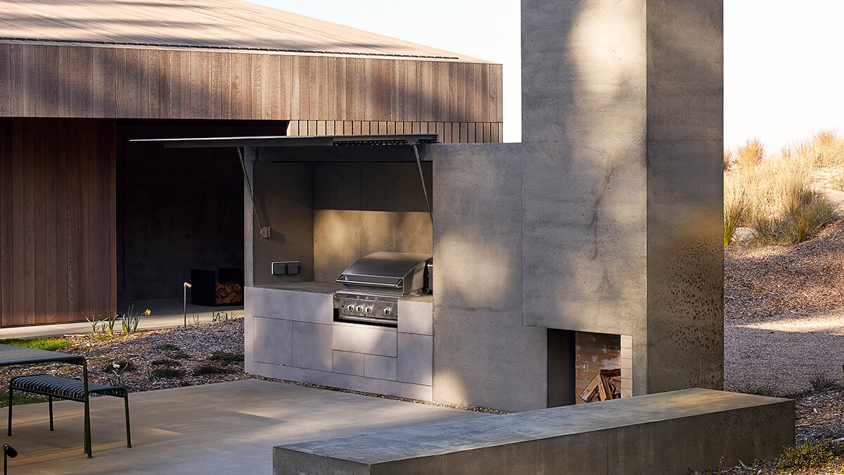 Outdoor entertainment area featuring a grill hidden away behind a wall.
