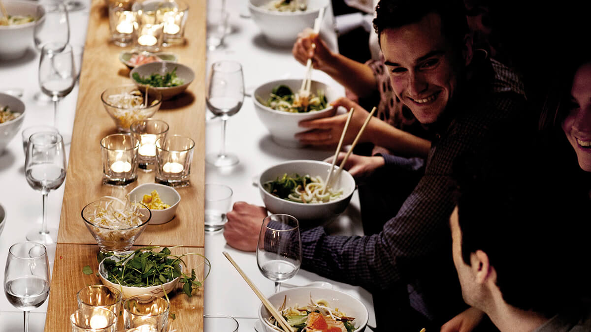 People eating and socialising at a formal dinner.