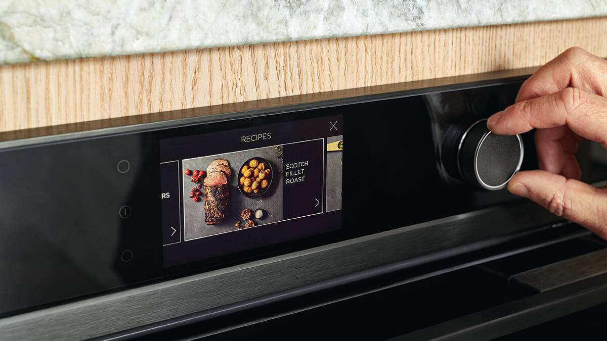 Close up of hand spinning dial of the touchscreen oven.