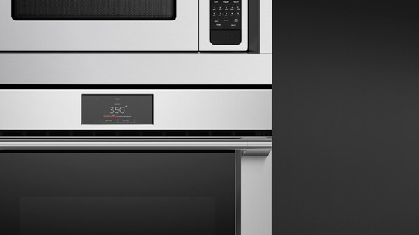 Front View of a Stainless Steel Professional Style Microwave Oven atop a Matching Oven Seamlessly Framed by a Trim Kit.