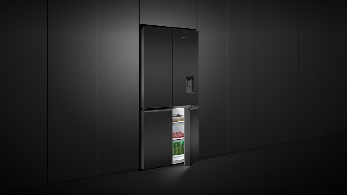 Fisher & Paykel Black Matte Glass Quad Door Refrigerator with an Open Freezer Door surrounded by Black Panel Cabinetry.