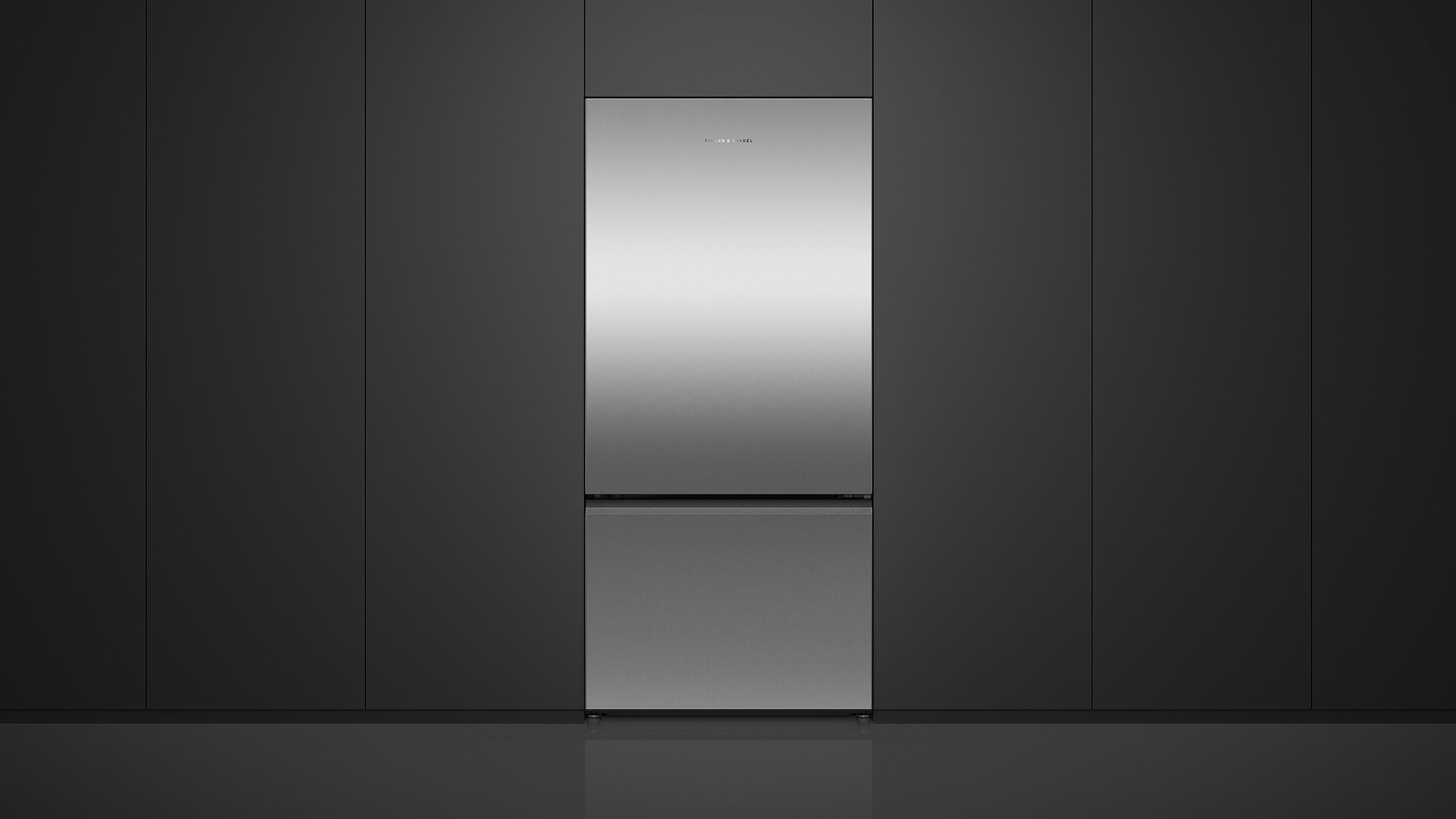 A freestanding stainless steel refrigerator in a bright, modern kitchen setting