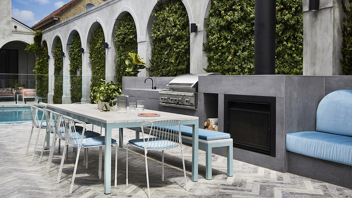 Outside shot of the home showing outdoor furniture with a pool in the background