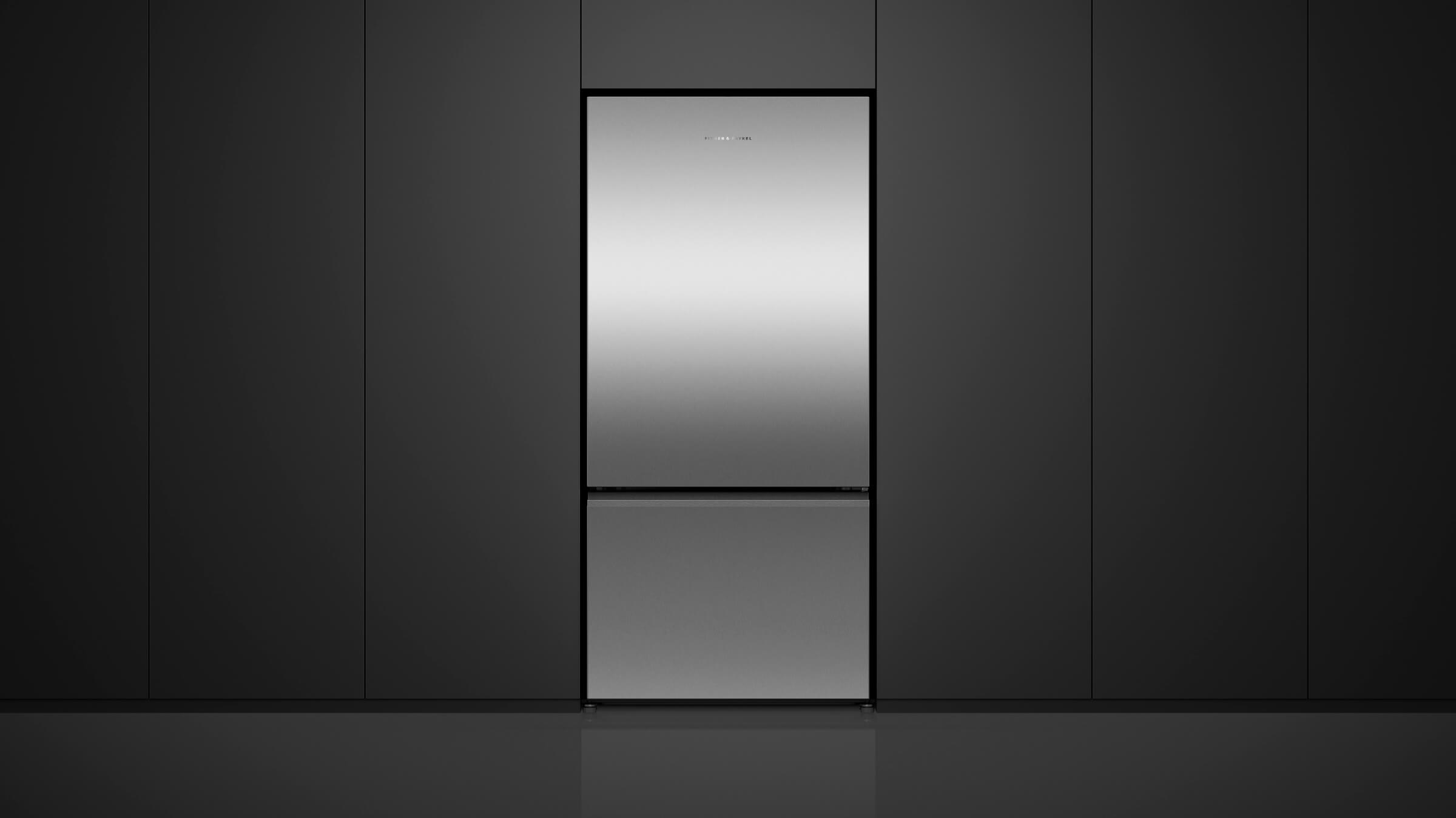 A freestanding stainless steel refrigerator in a bright, modern kitchen setting