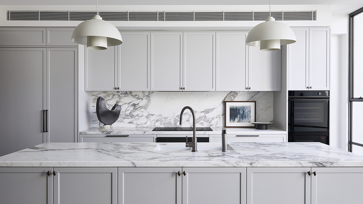 Interior shot of a kitchen featuring a marble island in the foreground