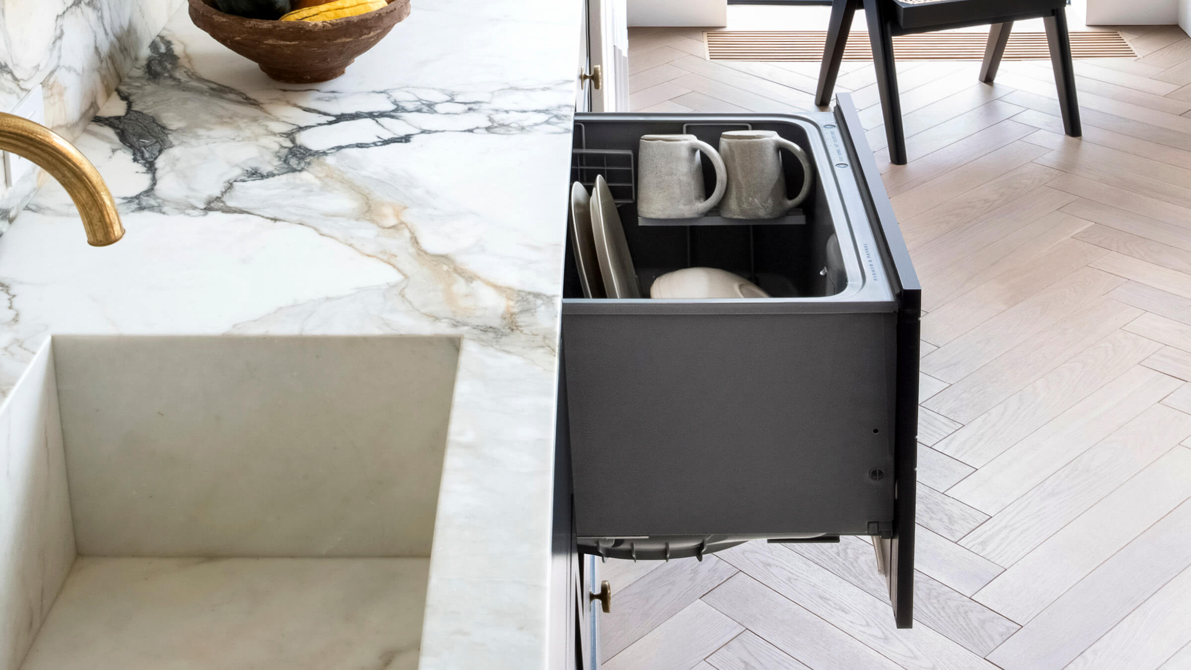 Side View of Brass Tap, Marble Countertop and Open DishDrawer Dishwasher.