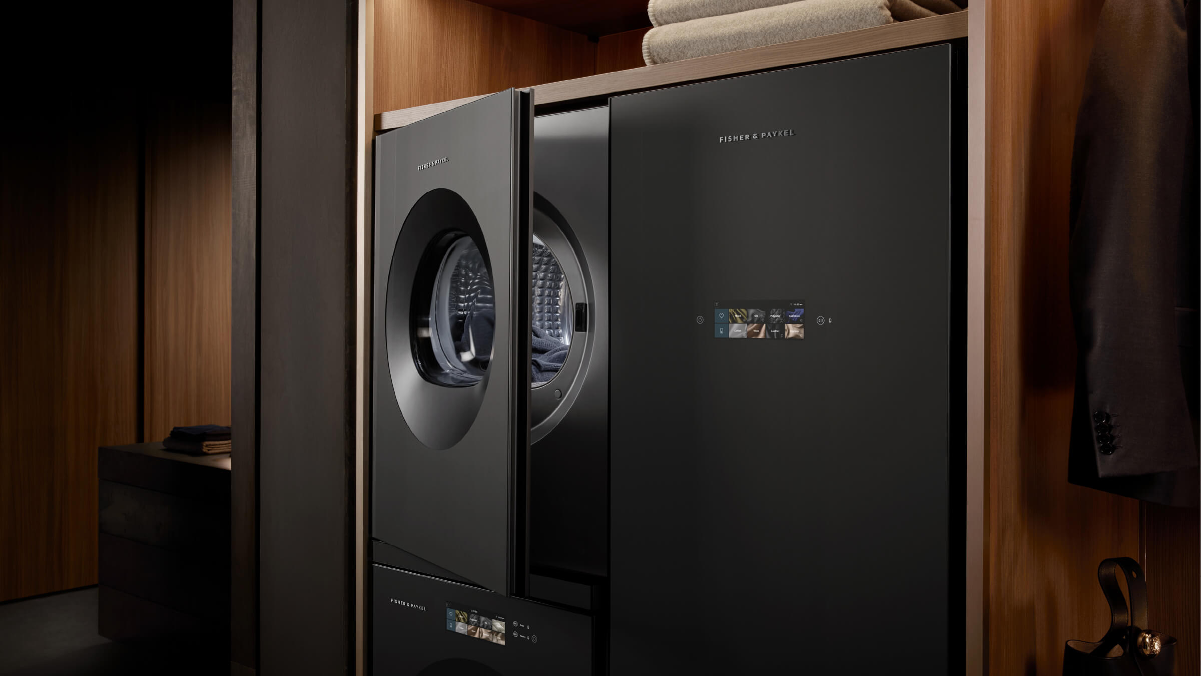 Dark laundry appliances integrated into a warm timber cabinetry setting