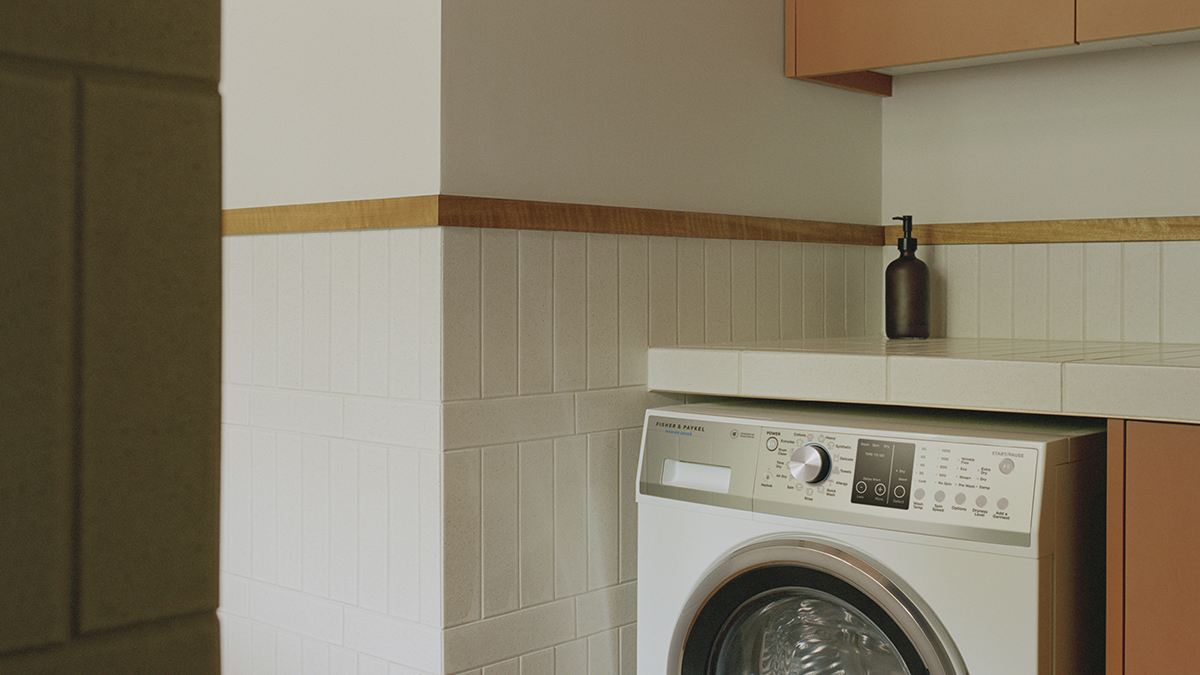 close up interior of the laundry featuring a Fisher & Paykel front load washing machine