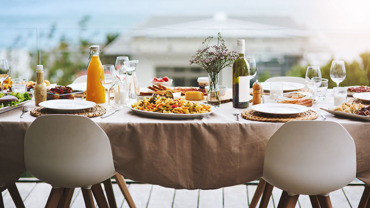 Al Fresco Dining Table Set on a Balcony Overlooking a Blurred Out Seaview.