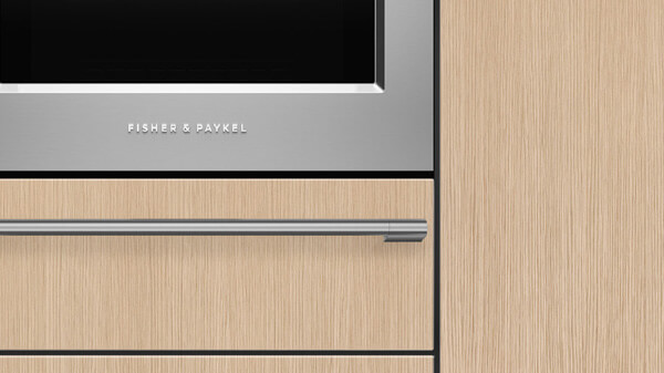 Front View of a Stainless Steel Professional Style Microwave Oven atop a Matching Oven Seamlessly Framed by a Trim Kit.