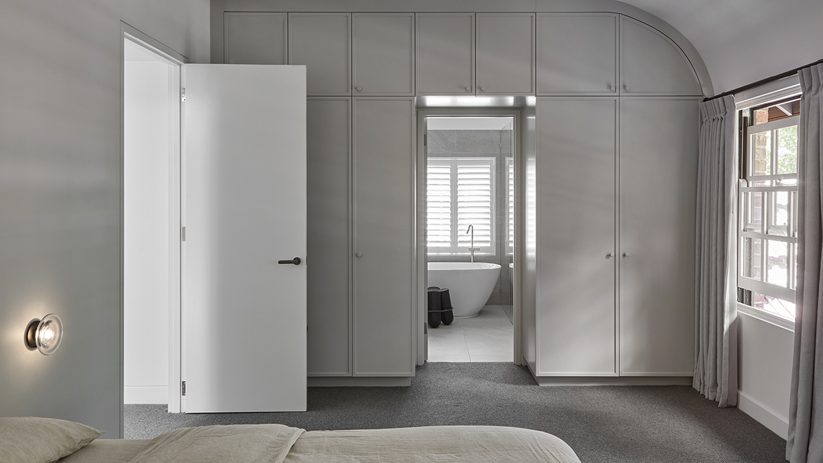 Master bedroom showing grey cabinetry with a view into the ensuite bathroom