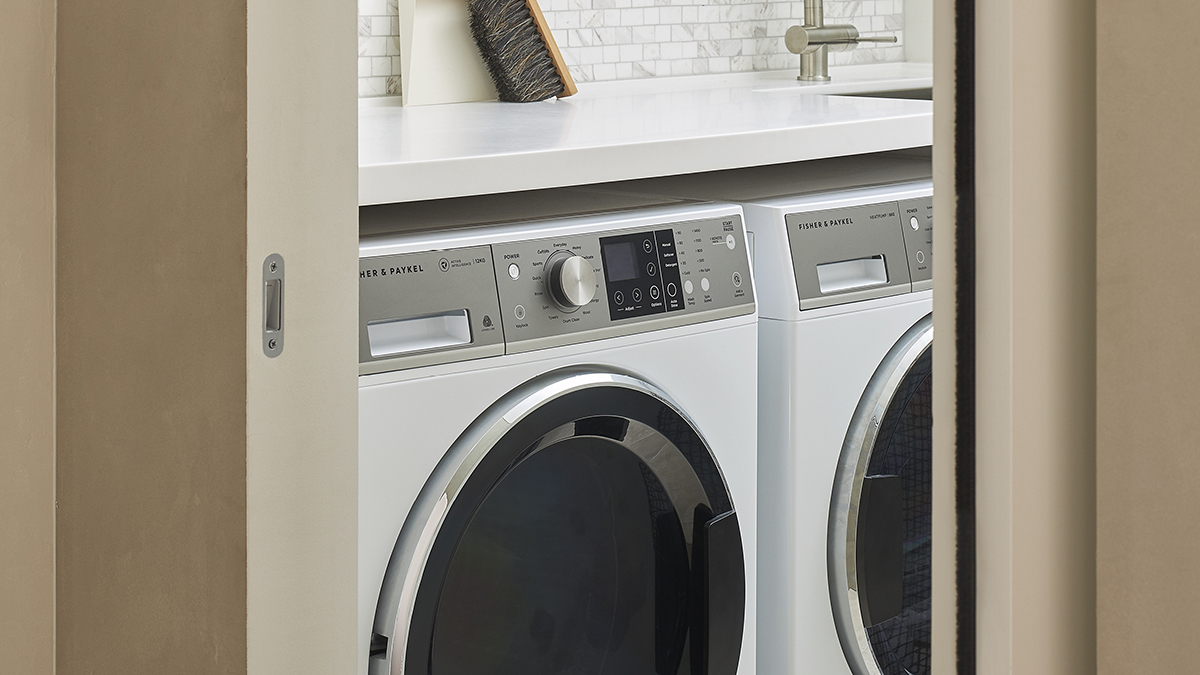 close up shot of the laundry room featuring a Fisher & Paykel washing machine and dryer