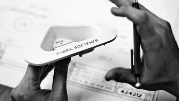 Close Up of Designer's Hands Holding Washing Machine Part and Pencil.